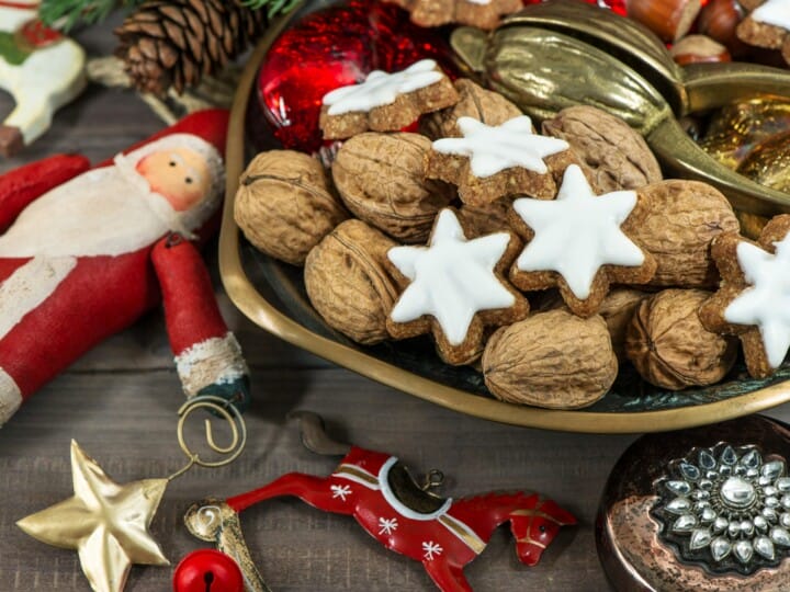 christmas cookies and walnuts with vintage decorations on wooden background